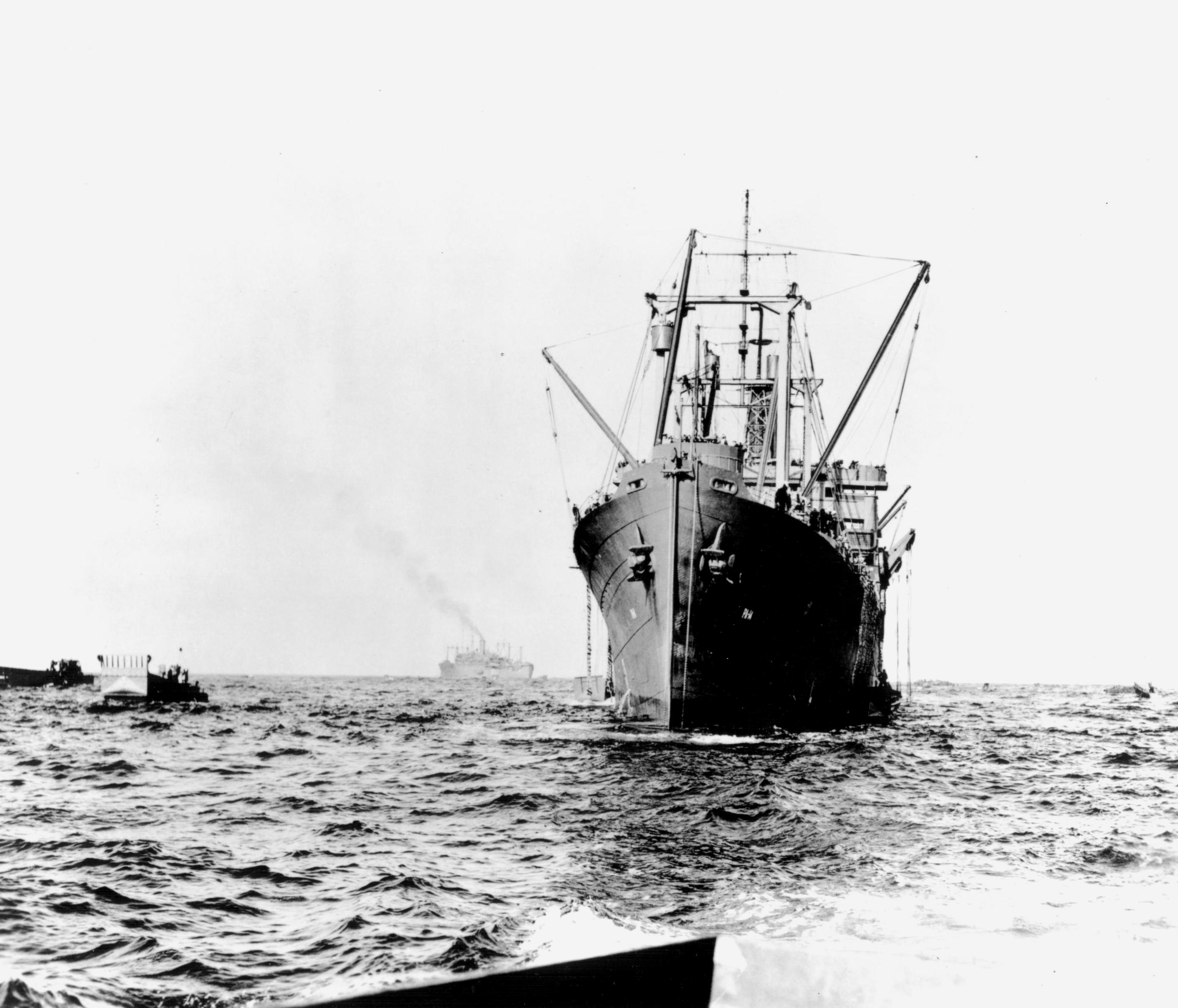 Rare photograph of the USS Hunter Liggett debarking troops for the Guadalcanal landings in August 1942. Notice the use of cargo derricks to lower landing craft into the water. (Courtesy of the U.S. Navy)