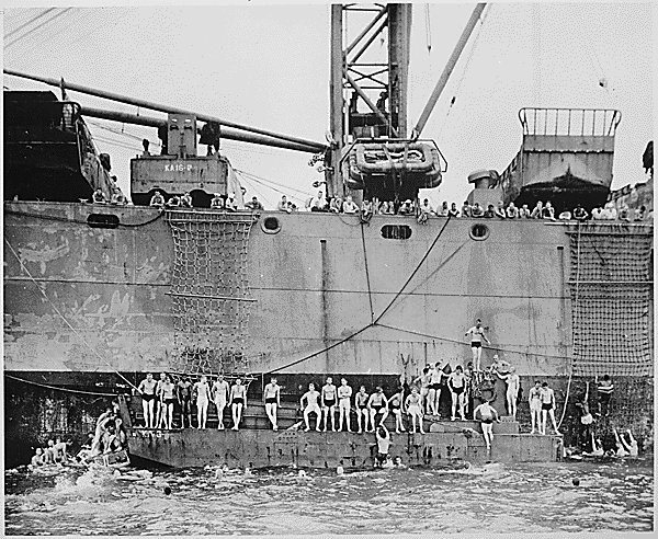 Swim call on board USS Aquarius using a landing craft for swim platform and cargo nets for ladders. (U.S. Coast Guard)