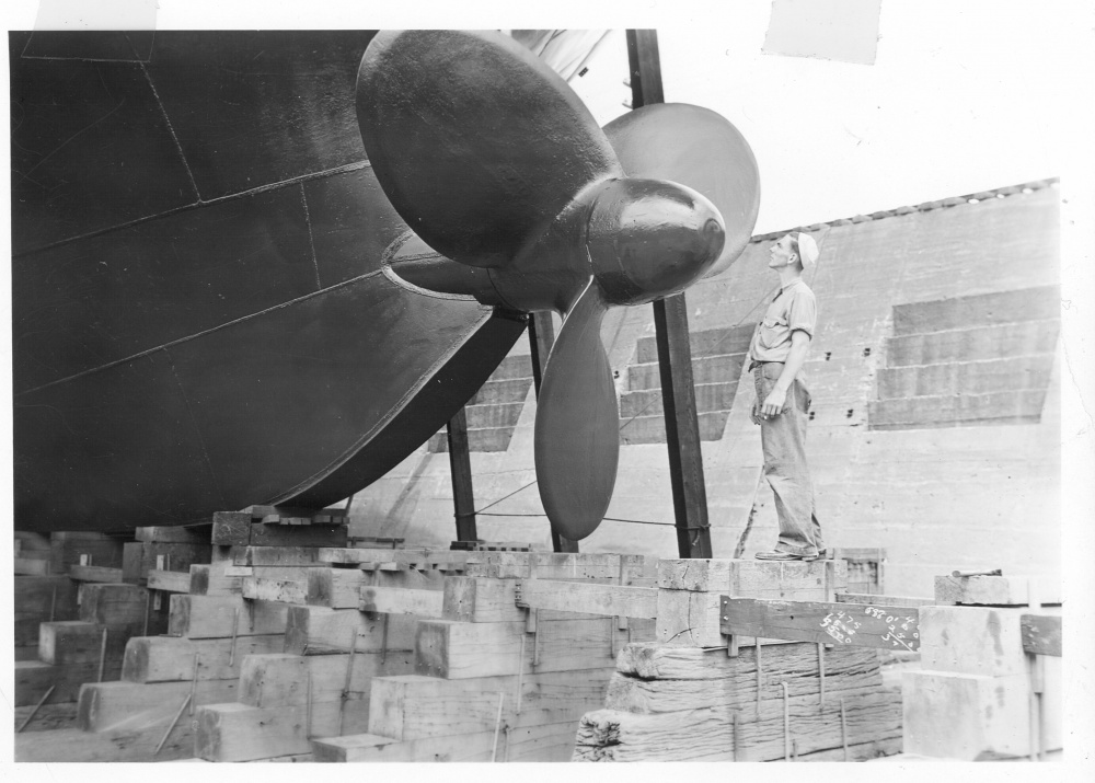 A Coast Guardsman stands next to Mackinaw’s unique bow propeller designed to help break ice. (U.S. Coast Guard)